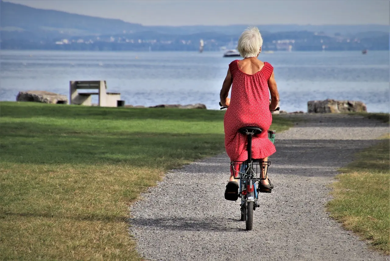 En äldre kvinna cyklar vid havet